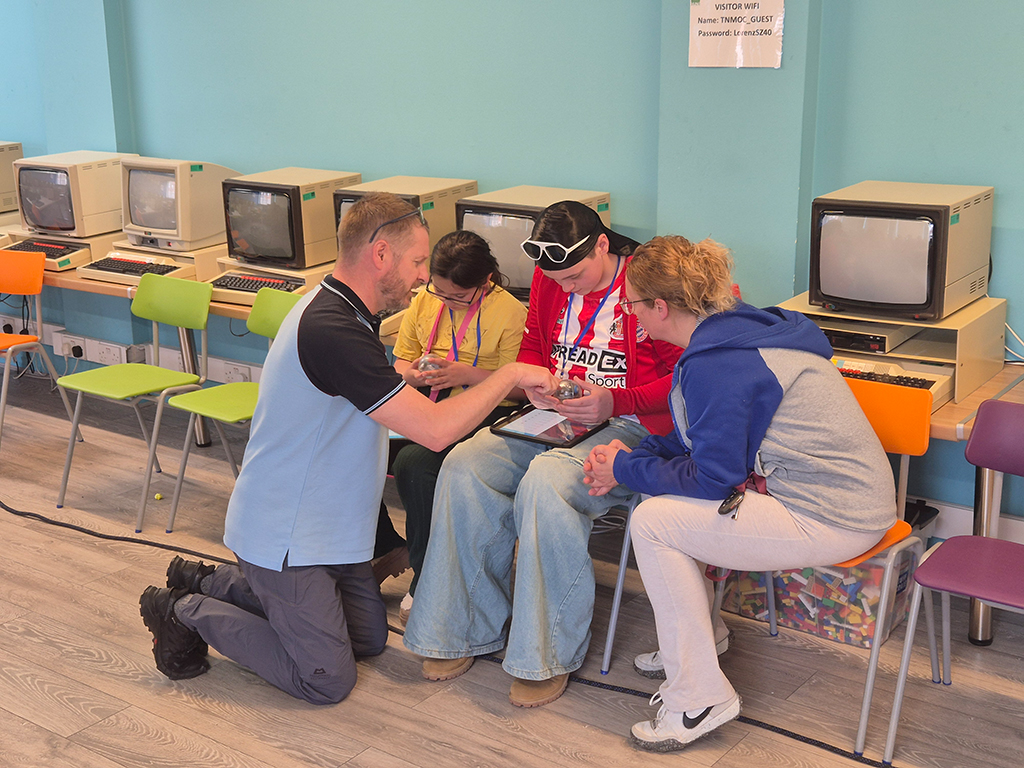 A student group engaged in programming their robot